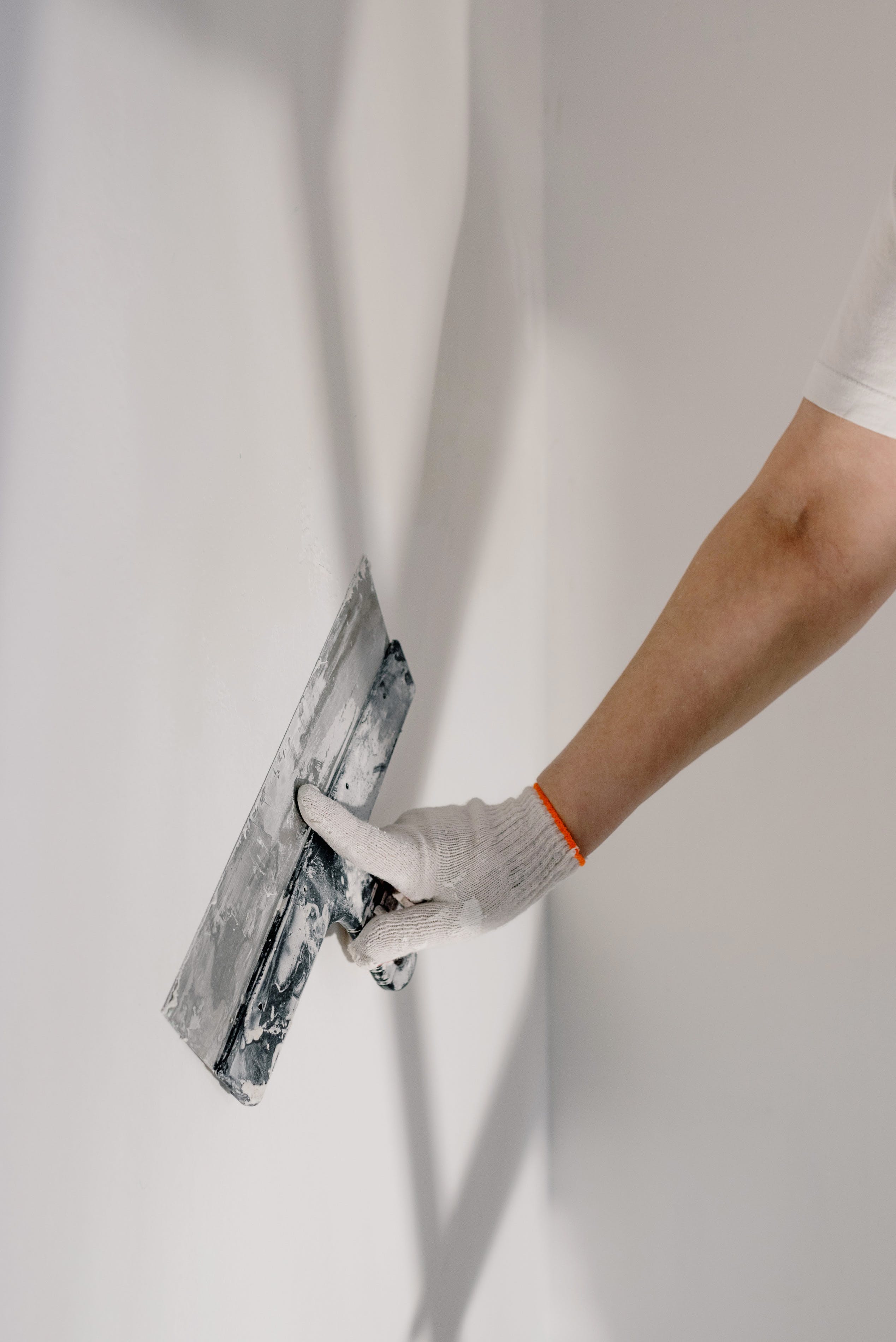 applying adhesive to wall with a tool